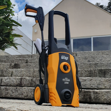 Lavadora de alta pressão WAP Eco Wash 2200 amarela sobre degraus de pedra, com vegetação ao fundo.