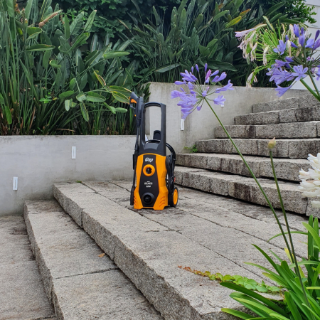 Lavadora de alta pressão WAP Eco Wash 2200 amarela sobre degraus de pedra, com vegetação ao fundo. 2